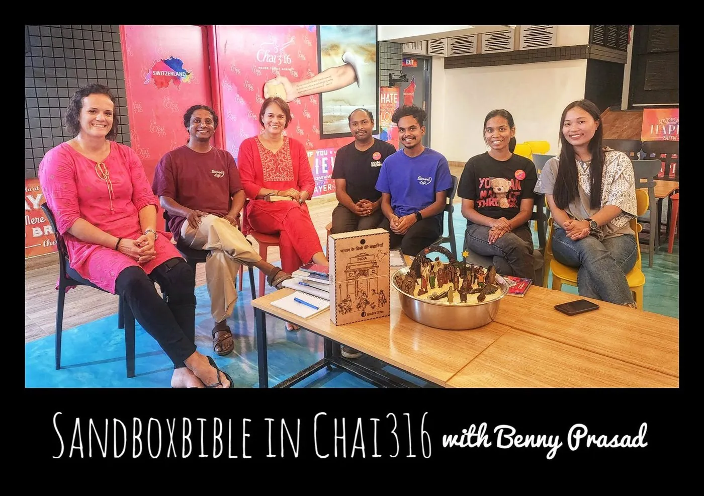 Several women seated at a table with books and a bowl, captioned SandBoxBible in Chai316 with Benny Prasad.